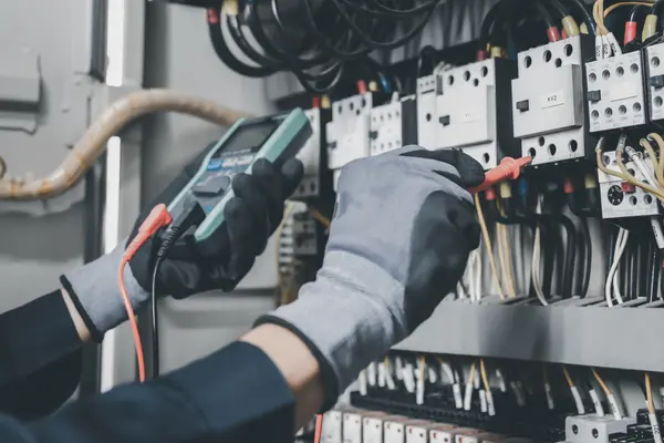 someone using a multimer to test brakers installed in an electrical panel from Electrician Richardson TX in Richardson, TX - Alarm system installation