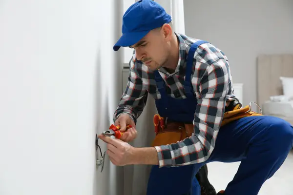 a male electrician installing a electrical outlet from Electrician Richardson TX in Richardson, TX - Electrical ceiling fan installation