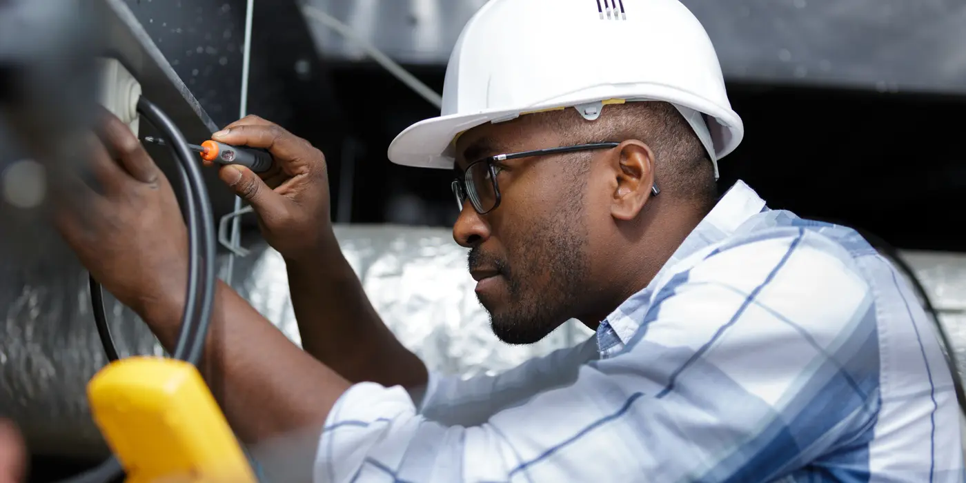 a black male electrician fixing an electrical outlet from Electrician Richardson TX in Richardson, TX - Electrical wiring redesign